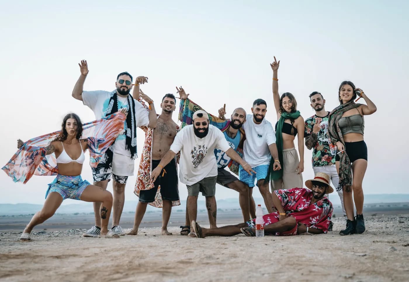 קבוצה מצטלמת יחד על הערבה בשעת בין ערביים